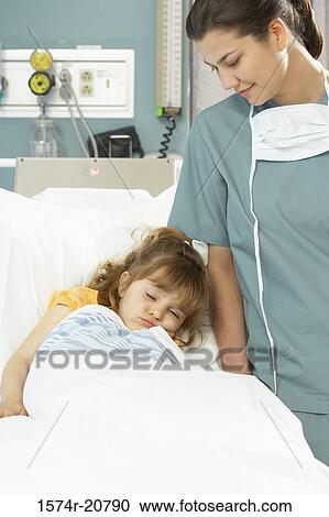 Girl sleeping on the bed and a female nurse standing beside her View Large Photo Image Stock Image - Girl sleeping on the bed and a female nurse standing beside her. Fotosearch