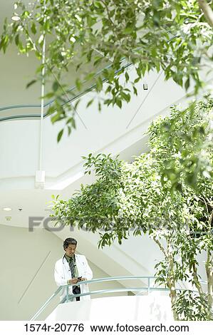 Low angle view of a male doctor leaning over a hand rail View Large Photo Image Stock Photograph - Low angle view of a male doctor leaning over a hand rail. Fotosearch