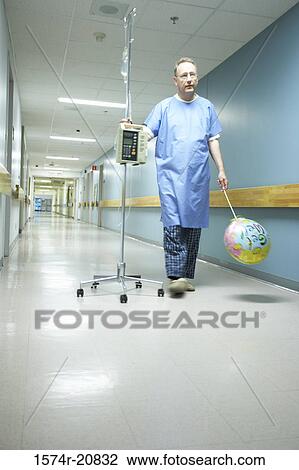 Low angle view of a male patient walking with an IV drip stand View Large Photo Image Stock Image - Low angle view of a male patient walking with an IV drip stand. Fotosearch