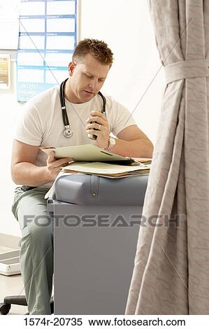 Male doctor reading a document View Large Photo Image Stock Photography - Male doctor reading a document. Fotosearch