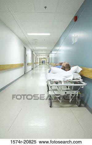Male patient lying on a stretcher in the corridor of a hospital View Large Photo Image Stock Photography - Male patient lying on a stretcher in the corridor of a hospital. Fotosearch