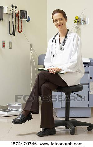 Portrait of a female doctor sitting on a stool and smiling View Large Photo Image Stock Photograph - Portrait of a female doctor sitting on a stool and smiling. Fotosearch