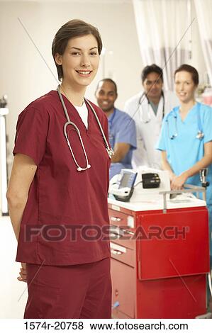 Portrait of a female doctor smiling with her colleagues in the background View Large Photo Image Stock Photo - Portrait of a female doctor smiling with her colleagues in the background. Fotosearch
