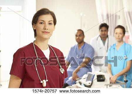 Portrait of a female doctor standing with her colleagues in the background View Large Photo Image Stock Photo - Portrait of a female doctor standing with her colleagues in the background. Fotosearch
