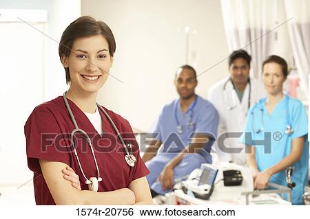 Portrait of a female doctor standing with her arms crossed and her colleagues in the background View Large Photo Image Stock Photograph - Portrait of a female doctor standing with her arms crossed and her colleagues in the background. Fotosearch