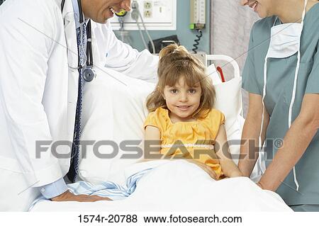 Portrait of a girl sitting on the bed with a nurse and a male doctor standing beside her View Large Photo Image Stock Photo - Portrait of a girl sitting on the bed with a nurse and a male doctor standing beside her. Fotosearch