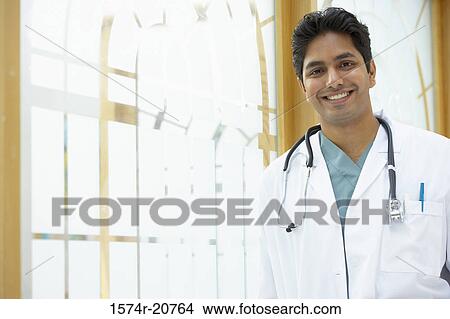 Picture - Portrait of a male doctor smiling with a stethoscope around his neck. Fotosearch