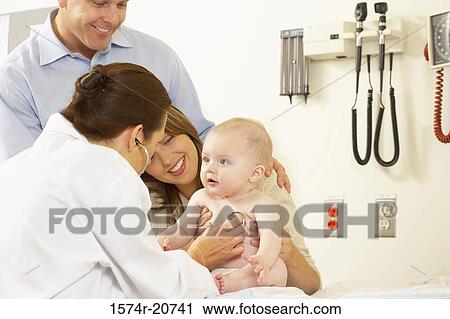 Stock Image - Side profile of a female doctor examining a baby boy with a stethoscope. Fotosearch