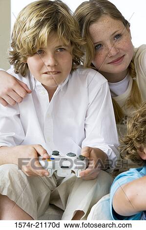 Close-up of a boy playing a video game with his friends View Large Photo Image Stock Image - Close-up of a boy playing a video game with his friends. Fotosearch
