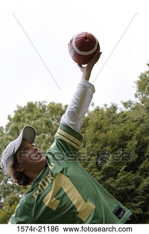 Close-up of a boy playing with a football View Large Photo Image Stock Photograph - Close-up of a boy playing with a football. Fotosearch