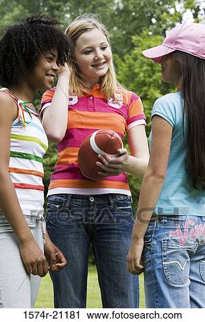 Close-up of three girls talking to each other in a park View Large Photo Image Stock Image - Close-up of three girls talking to each other in a park. Fotosearch