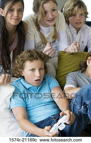 High angle view of a boy playing a video game with his friends View Large Photo Image Stock Image - High angle view of a boy playing a video game with his friends. Fotosearch