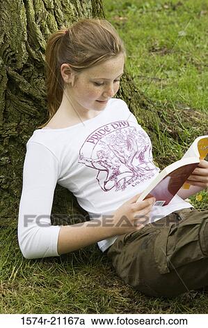 High angle view of a girl reading a book View Large Photo Image Stock Image - High angle view of a girl reading a book. Fotosearch
