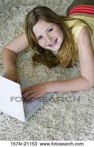 High angle view of a girl using a laptop View Large Photo Image Stock Image - High angle view of a girl using a laptop. Fotosearch
