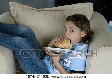 Portrait of a boy eating a burger View Large Photo Image Stock Image - Portrait of a boy eating a burger. Fotosearch