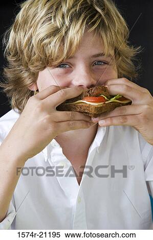 Stock Photography - Portrait of a boy eating a sandwich. Fotosearch