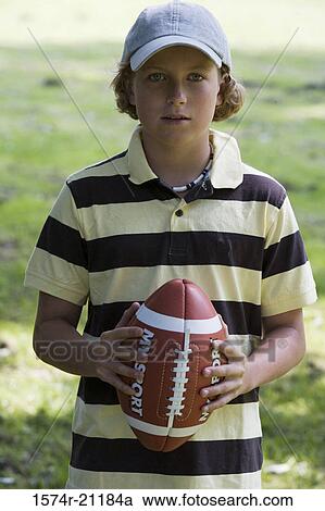 Portrait of a boy holding a football View Large Photo Image Stock Image - Portrait of a boy holding a football. Fotosearch