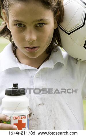 Stock Image - Portrait of a boy holding a soccer ball and a water bottle. Fotosearch