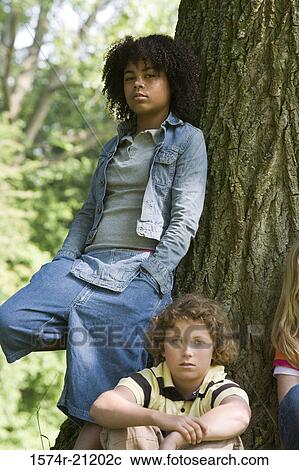 Stock Image - Portrait of a girl with a boy near a tree in a park. Fotosearch