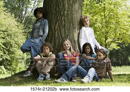 Stock Image - Portrait of a group of children resting in a park. Fotosearch