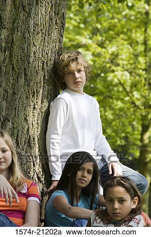 Portrait of two boys and two girls resting in a park View Large Photo Image Stock Image - Portrait of two boys and two girls resting in a park. Fotosearch