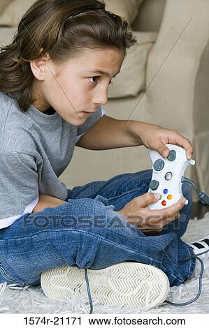Side profile of a boy playing a video game View Large Photo Image Stock Image - Side profile of a boy playing a video game. Fotosearch