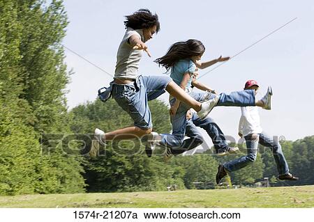 Side profile of four children jumping in a park View Large Photo Image Stock Image - Side profile of four children jumping in a park. Fotosearch