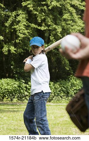 Stock Image - Two children playing baseball in a park. Fotosearch