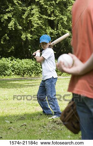 Two children playing baseball in a park View Large Photo Image Stock Image - Two children playing baseball in a park. Fotosearch