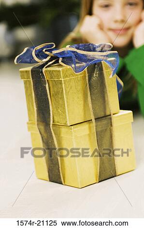 Girl looking at Christmas presents View Large Photo Image Stock Photography - Girl looking at Christmas presents. Fotosearch