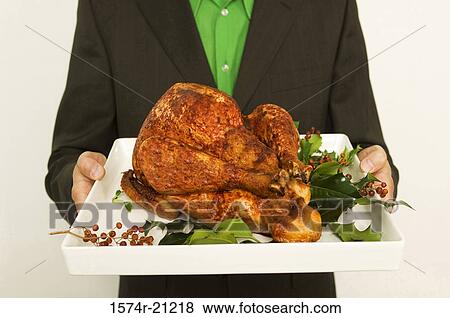 Mid section view of a man holding a roasted turkey on a tray View Large Photo Image Stock Photo - Mid section view of a man holding a roasted turkey on a tray. Fotosearch