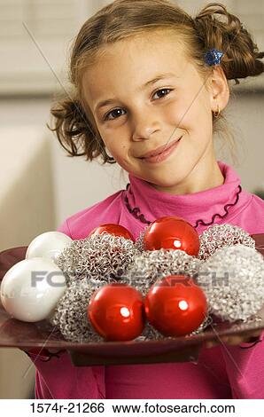 Portrait of a girl holding a tray of Christmas balls View Large Photo Image Stock Photograph - Portrait of a girl holding a tray of Christmas balls. Fotosearch