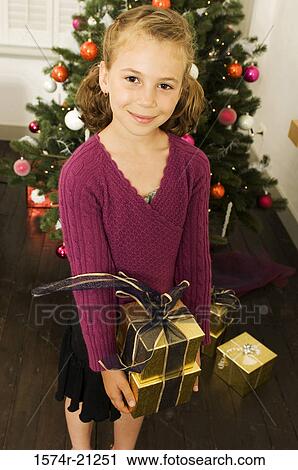 Portrait of a girl holding two Christmas presents and smiling View Large Photo Image Stock Image - Portrait of a girl holding two Christmas presents and smiling. Fotosearch