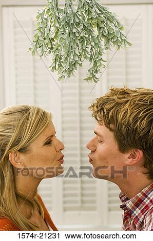 Side profile of a mid adult man and a young woman facing each other and puckering their lips View Large Photo Image Stock Image - Side profile of a mid adult man and a young woman facing each other and puckering their lips. Fotosearch