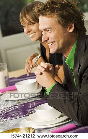 Side profile of a mid adult man with a young woman smiling at a dining table View Large Photo Image Stock Image - Side profile of a mid adult man with a young woman smiling at a dining table. Fotosearch