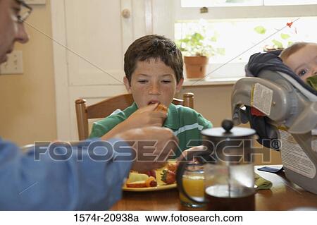Boy having breakfast with his father View Large Photo Image Stock Image - Boy having breakfast with his father. Fotosearch