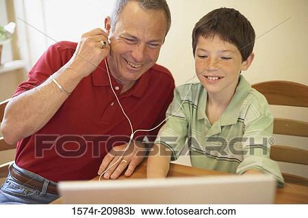 Close-up of a boy and his grandfather wearing headphones and listening to music View Large Photo Image Stock Image - Close-up of a boy and his grandfather wearing headphones and listening to music. Fotosearch