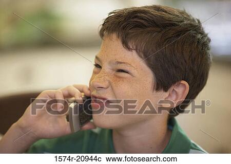 Close-up of a boy using a mobile phone and making a face View Large Photo Image Stock Image - Close-up of a boy using a mobile phone and making a face. Fotosearch