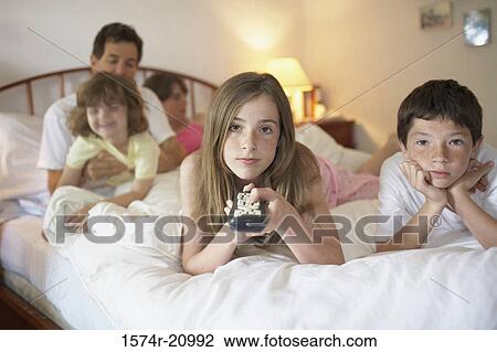 Close-up of a teenage girl and her brother lying in the bed watching TV View Large Photo Image Stock Image - Close-up of a teenage girl and her brother lying in the bed watching TV. Fotosearch