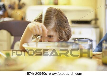 Girl sitting at a dining table View Large Photo Image Stock Image - Girl sitting at a dining table. Fotosearch