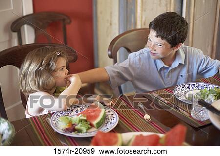 High angle view of a boy and his sister sitting at a dining table and looking at each other View Large Photo Image Stock Photo - High angle view of a boy and his sister sitting at a dining table and looking at each other. Fotosearch