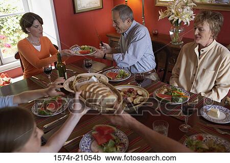 High angle view of a family sitting at a dining table View Large Photo Image Stock Image - High angle view of a family sitting at a dining table. Fotosearch