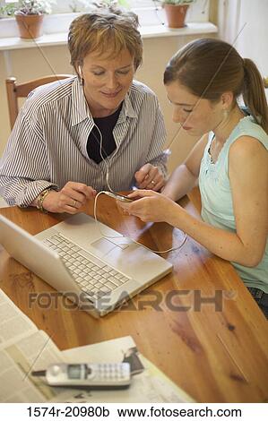 High angle view of a teenage girl and her grandmother wearing headphones and listening to music View Large Photo Image Stock Image - High angle view of a teenage girl and her grandmother wearing headphones and listening to music. Fotosearch