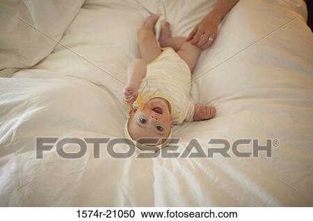 Portrait of a baby boy lying on the bed View Large Photo Image Stock Image - Portrait of a baby boy lying on the bed. Fotosearch