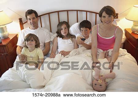 Stock Image - Portrait of a mid adult couple with their two daughters and two sons in the bed. Fotosearch