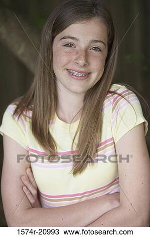 Portrait of a teenage girl smiling with her arms crossed View Large Photo Image Stock Image - Portrait of a teenage girl smiling with her arms crossed. Fotosearch