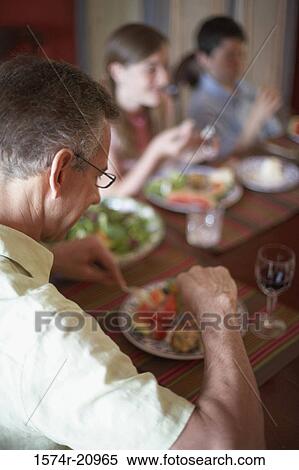 Side profile of a father sitting with his son and daughter at a dining table View Large Photo Image Stock Photography - Side profile of a father sitting with his son and daughter at a dining table. Fotosearch