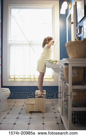 Side profile of a girl brushing her teeth in the bathroom View Large Photo Image Stock Image - Side profile of a girl brushing her teeth in the bathroom. Fotosearch