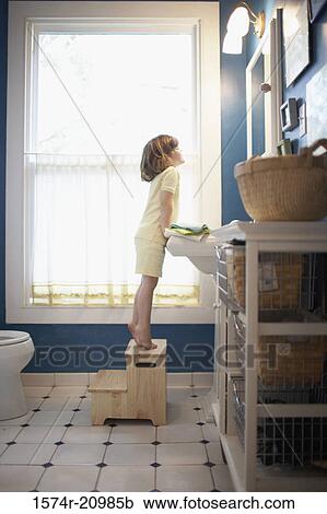 Side profile of a girl looking at a mirror in the bathroom View Large Photo Image Stock Image - Side profile of a girl looking at a mirror in the bathroom. Fotosearch