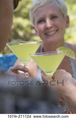 Close-up of a mature couple toasting with martini glasses View Large Photo Image Stock Image - Close-up of a mature couple toasting with martini glasses. Fotosearch